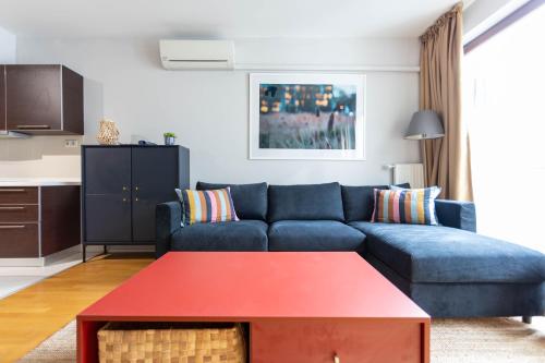 uma sala de estar com um sofá azul e uma mesa vermelha em Paulay65 Budapest em Budapeste