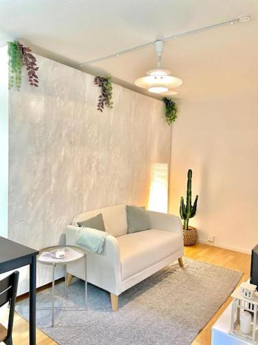 uma sala de estar com um sofá branco e uma mesa em Suite 505 nel cuore di Zurigo em Zurique