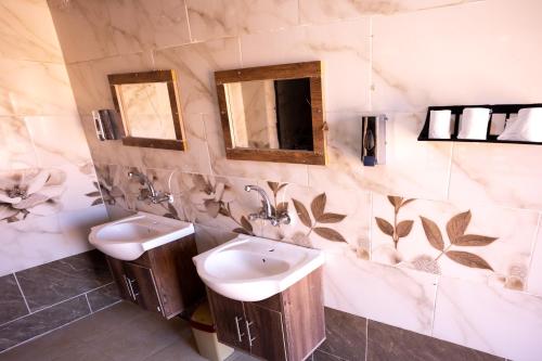 a bathroom with two sinks and a mirror at Wadi Rum Desert Heart Camp in Wadi Rum