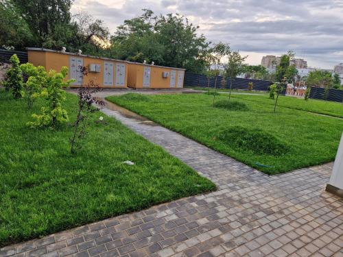 a brick walkway in a park with a building at XMX Jacuzzi and Baldachin Studio in Bucharest