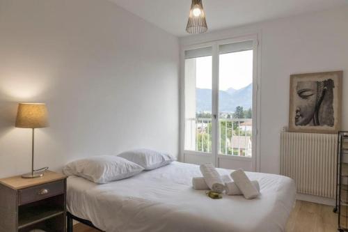 um quarto com uma cama branca e uma janela em Le Camille YourHostHelper em Rhut