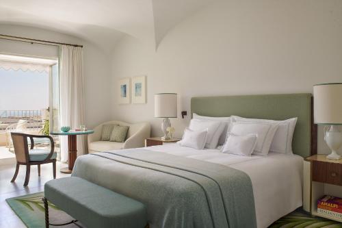 a bedroom with a large bed and a living room at Hotel La Palma Capri, an Oetker Collection Hotel in Capri