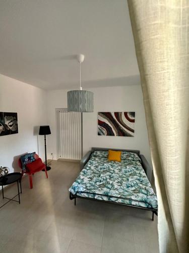 um quarto com uma cama e uma cadeira vermelha em La dimora del Cardinale em LʼAquila