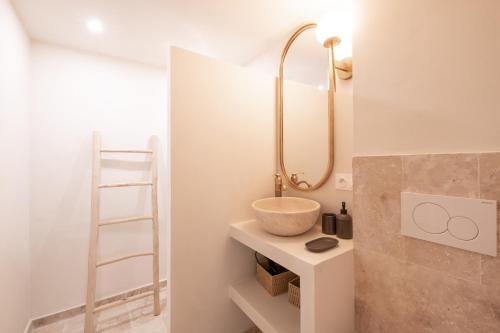 ein Badezimmer mit einem Waschbecken und einem Spiegel auf einem Regal in der Unterkunft Pick A Flat's Apartments in Saint-Tropez - Rue des Bouchonniers in Saint-Tropez