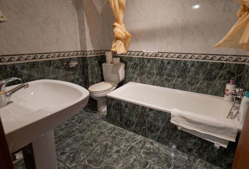 La salle de bains est pourvue d'une baignoire, de toilettes et d'un lavabo. dans l'établissement Alojamiento Rural Casa Ezkerra, 