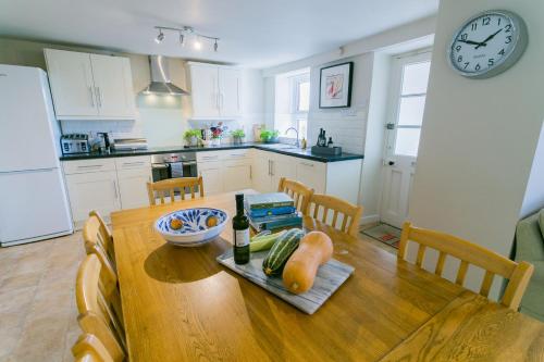 a kitchen with a wooden table with a plate of food at Tyn Lon in Moelfre