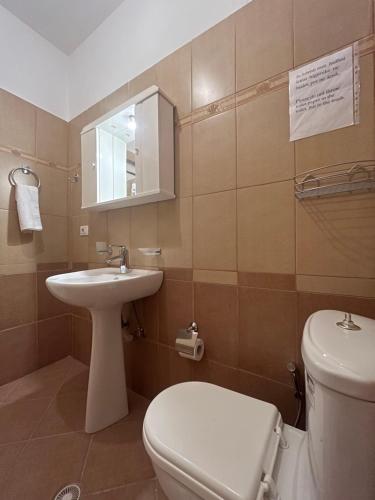 a bathroom with a toilet and a sink at Miranda's Apartments & Rooms in Sarandë