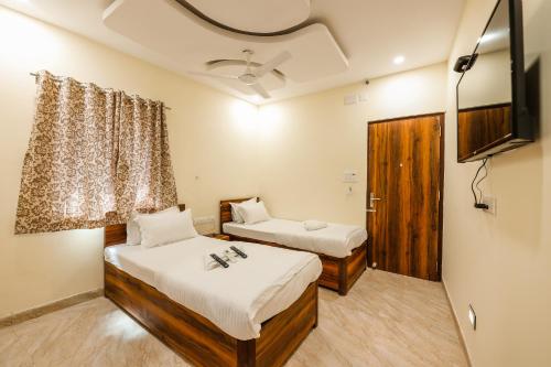 Habitación con 2 camas y TV. en Hotel Holiday Express, en Calcuta