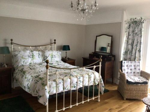um quarto com uma cama, um espelho e um lustre em Océan Waves em Gorleston-on-Sea
