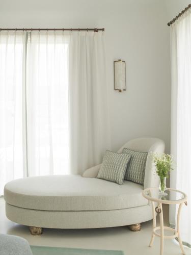 a white living room with a couch and a table at Hotel La Palma, Oetker Hotels in Capri