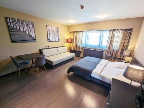 una camera d'albergo con un grande letto e un tavolo di Nitro Rooms a Lubiana
