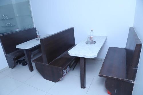 einen Tisch mit zwei Stühlen und einen Tisch mit einer Flasche darauf in der Unterkunft Hotel Kewal INN in Jālgaon