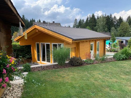 a small wooden house with a yard at Ferienwohnungen und Gästezimmer Herrmann in Steinbach am Wald