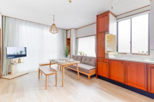 a living room with a table and a couch at Chikyuutabikazoku　Kintetsu-Nara Ekimae in Nara