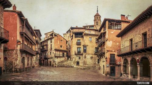 an old street in a town with a tower at El Rincón de Bezas in Bezas