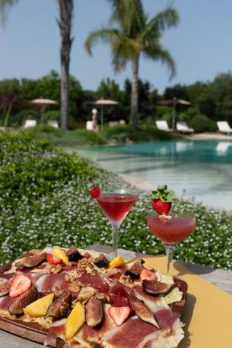a pizza on a table next to two glasses at Sant Efis Hotel in Pula