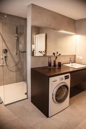 a kitchen with a washing machine and a sink at Puenlandhof in Brunico
