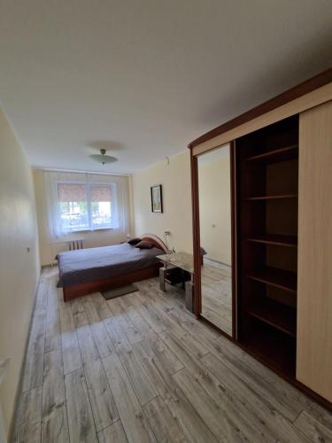 une chambre avec un lit et un parquet dans l'établissement Lima C, à Druskininkai