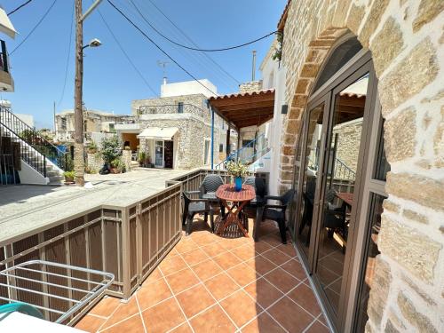 een patio met een tafel en stoelen op een balkon bij Camara House in Pitsidia