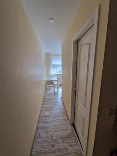 pusty korytarz z drzwiami i stołem w obiekcie Lima C w Druskienikach