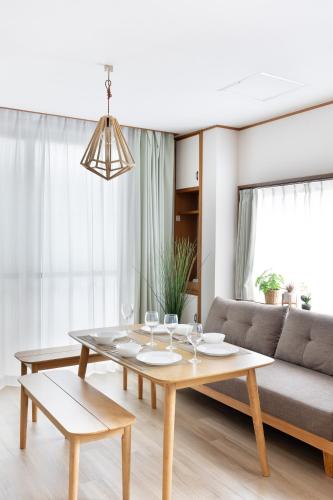 a living room with a table and a couch at Chikyuutabikazoku　Kintetsu-Nara Ekimae in Nara