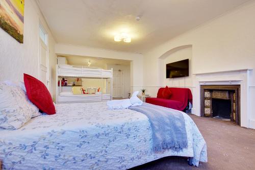 a bedroom with a large bed and a fireplace at Bourne Hall Annexe in Bournemouth