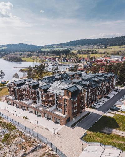 an aerial view of an apartment complex with a river at MOLO LIPNO RESIDENCE in Lipno nad Vltavou