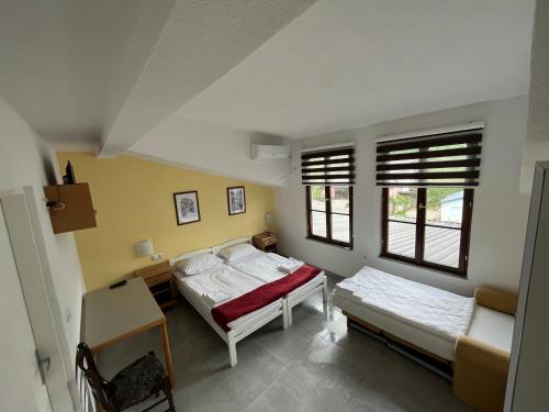 a bedroom with two beds and two windows at River View in Lohovo