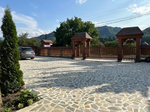a driveway with a fence and two gazebos at Casa Maramureșană in Vişeu de Sus