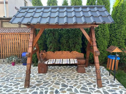 a wooden gazebo with a bench under it at Casa Maramureșană in Vişeu de Sus