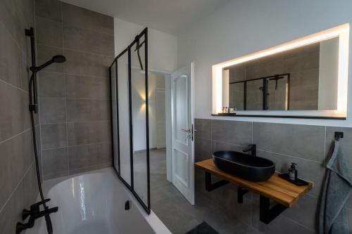 a bathroom with a sink and a bath tub at Eifel21 - stilvolles Haus in der Vulkaneifel in Bleckhausen