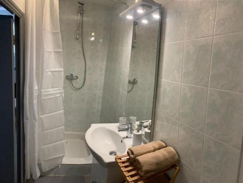 ein weißes Bad mit einem Waschbecken und einer Dusche in der Unterkunft Studio cosy, rénové en plein centre-ville in Manosque