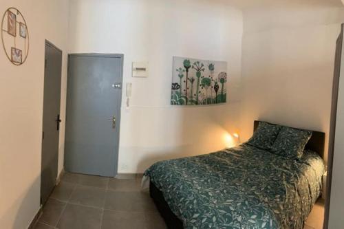 ein kleines Schlafzimmer mit einem Bett und einer Tür in der Unterkunft Studio cosy, rénové en plein centre-ville in Manosque