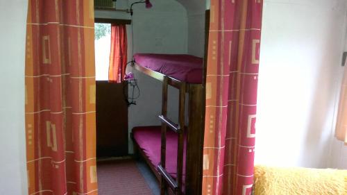 two bunk beds in a room with curtains at Retro maringotka č. 1 / Retro-trailer Nr. 1 in Zlatá Koruna