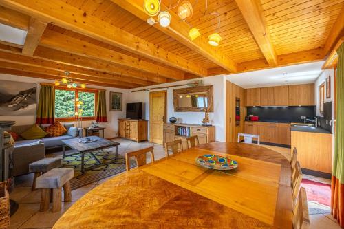 Il comprend un salon avec une table en bois et une cuisine. dans l'établissement Chalet La Vue, pet friendly 10 pers, amazing view, à Nendaz
