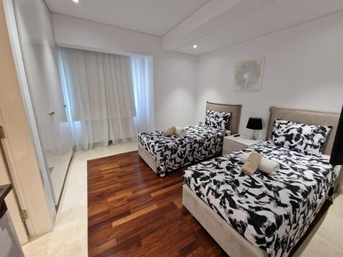 two beds in a room with wooden floors at Luxury 6 bedrooms villa in Cyprus in Paphos