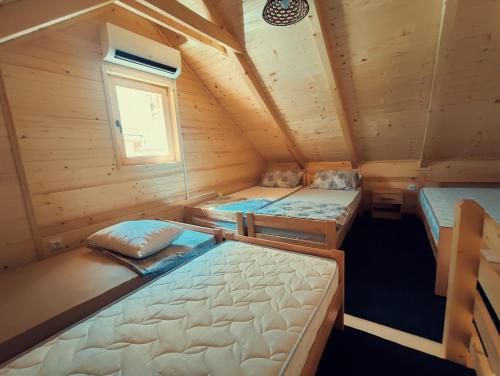1 dormitorio con 3 camas en una cabaña de madera en Guest house Nizama's Place, en Sarajevo