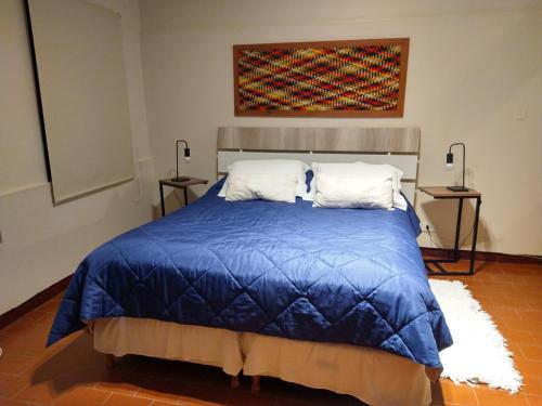 a bedroom with a bed with a blue comforter at Azules de Abril in Yerba Buena
