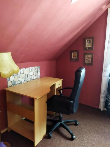a desk and a chair in a room with red walls at Samostatný domeček in Klášterec nad Ohří