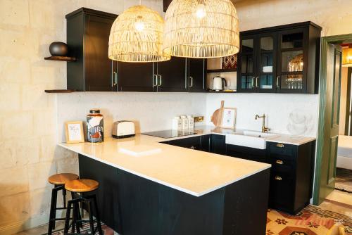 a kitchen with black cabinets and a sink and two chandeliers at A luxury apartment in Malta’s capital Valletta in Valletta