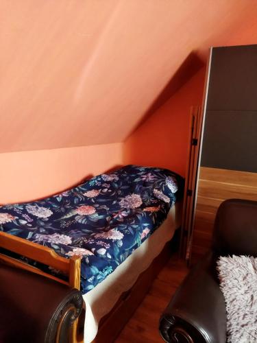 a small bedroom with a bed and a chair at Samostatný domeček in Klášterec nad Ohří