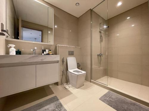 a bathroom with a toilet and a glass shower at Luxurious one-bedroom very close to Dubai Mall in Dubai