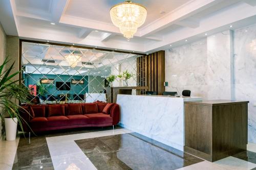 a lobby with a red couch and a counter at Highgarden Hotel in Tbilisi City