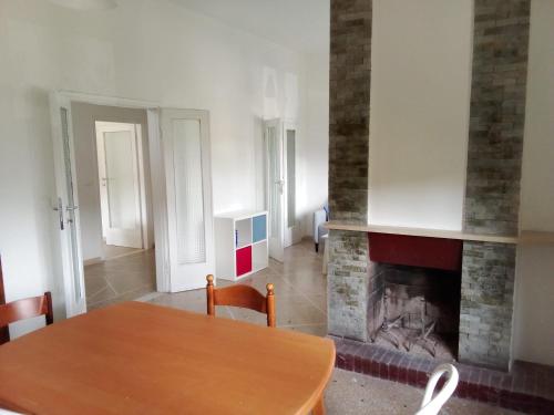 a dining room with a table and a fireplace at Casa Felci in Tirrenia