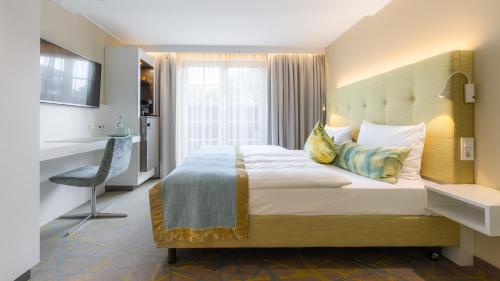 a bedroom with a large bed and a kitchen at Das Vesper in Sprockhövel