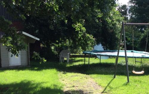 a picnic table in a yard with a trampoline at Kristinebjerg in Jelling
