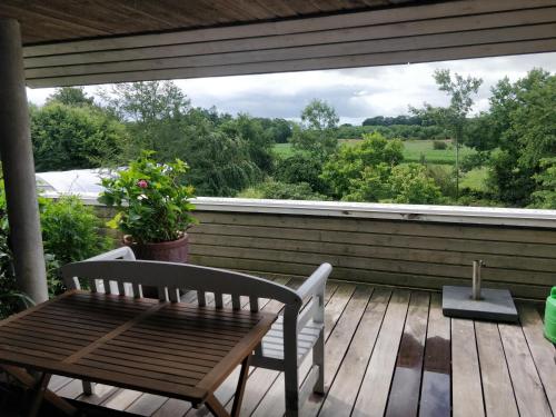 a porch with a wooden table and chairs and a window at Kristinebjerg in Jelling