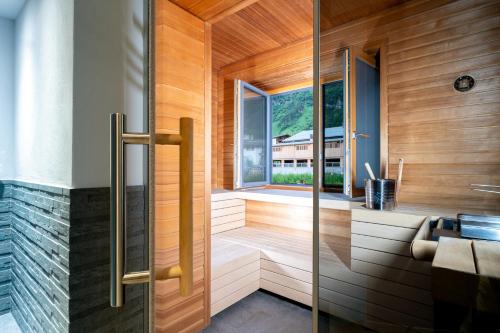 sauna z przeszklonymi drzwiami i oknem w obiekcie Apart-Hotel Laurus Lech w Lech am Arlberg
