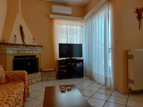 a living room with a tv and a couch and a fireplace at Oranje Guesthouse in Itea