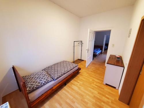 a bedroom with a bed and a wooden floor at VILLA LINDENECK ECONOMY in Bernburg